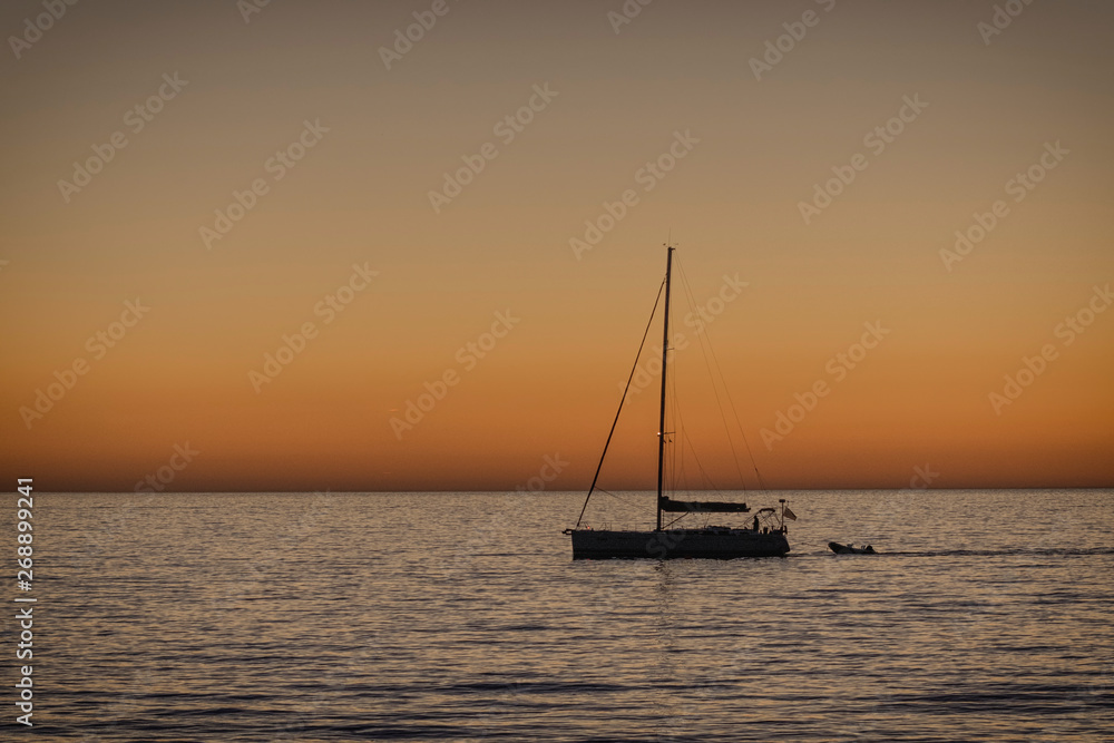 Sunset behind adriatic sea with boat, Slovenia