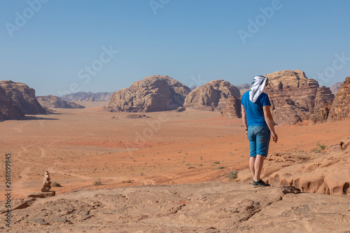 A tourist standing by the look out of a panoramic view of the desert in Wadi Rum  Jordan  Middle East.