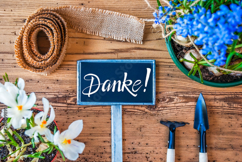 Sign With German Calligraphy Danke Means Thank You. Spring Flowers Like Grape Hyacinth And Crocus. Gardening Tools Like Rake And Shovel