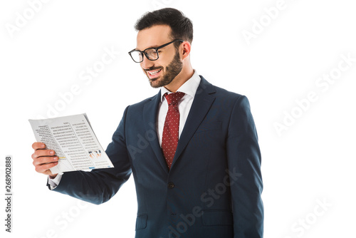 cheerful businessman in glassed reading newspaper isolated on white