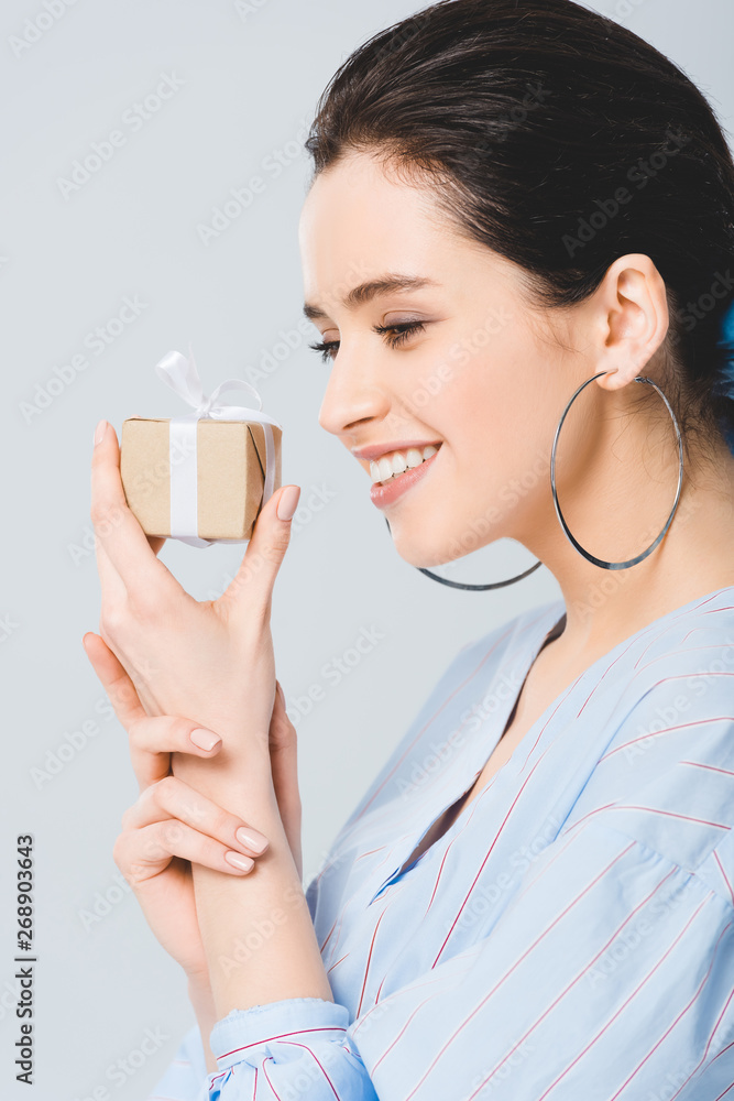beautiful stylish girl holding gift box and smiling isolated on grey beautiful stylish girl holding gift box and smiling isolated on grey