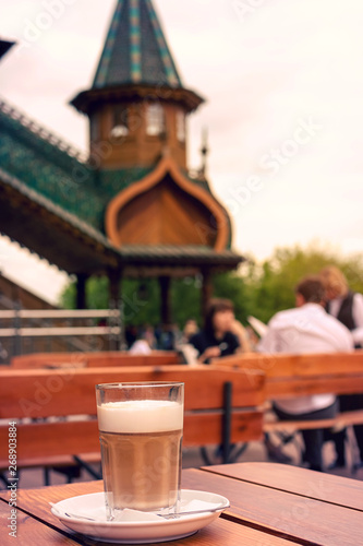 Fototapeta Naklejka Na Ścianę i Meble -  A glass of hot tasted latte with a spoon on a wooden table.
