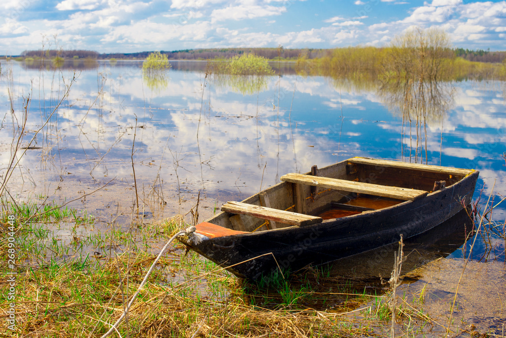 Old wooden boat near the river. Spring flood