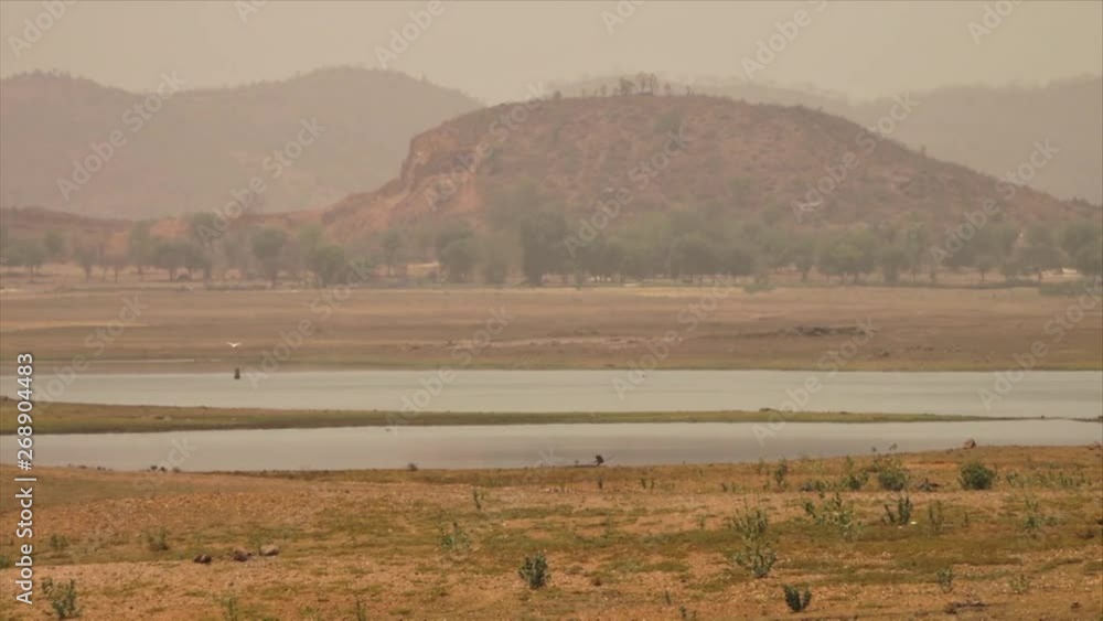 Wide low-angle panoramic still shot of Yamuna River plains, bird, and horizon Himalayan Ranges, India Wide low-angle panoramic still shot of Yamuna River plains, bird, and horizon Himalayan Ranges, India