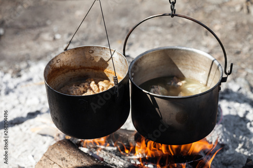 Cooking in two sooty old pots on campfire