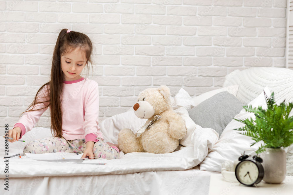 cute little girl drawing pictures while lying on bed. Kid painting at home cute little girl drawing pictures while lying on bed. Kid painting at home