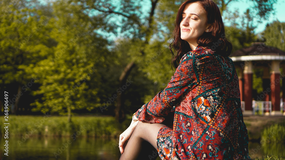 Portrait of woman in profile resting on the nature near the river. Sunny simmer day