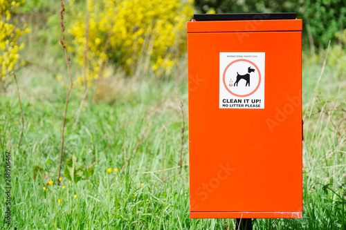 Dog fouling pick it up sign on red bin