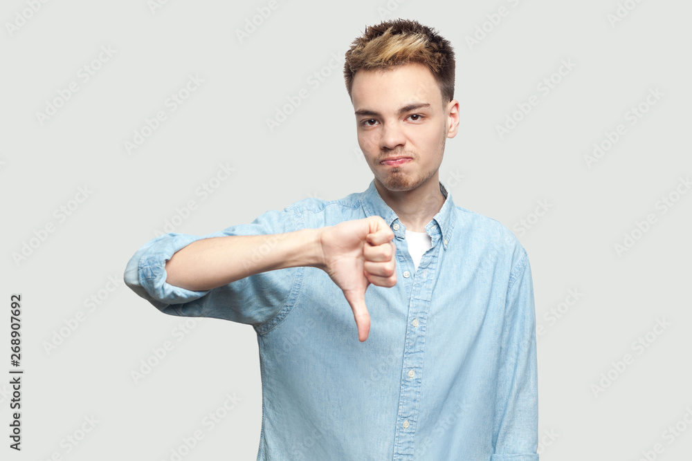 Dislike. Portrait of dissatisfied handsome young man in light blue 