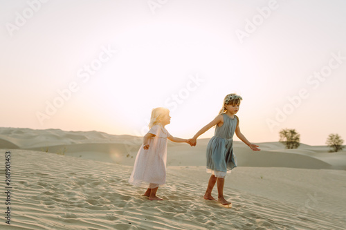 Two little beautiful girls in the desert in Dubai