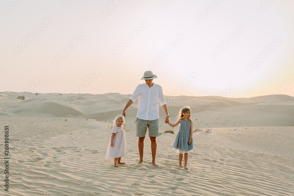 Young father having fun with his daughters in the desert