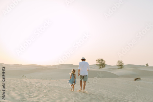 father with a daughter in the desert in Dubai