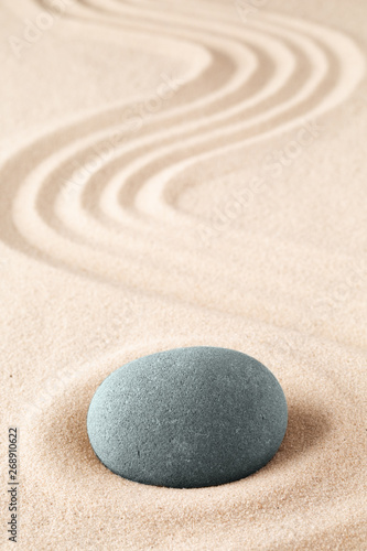 Stone meditation garden. Japanese zen concept for buddhism and mindfulness. Concept for concentration and fucusing. Round rock on sandy background with copy space.