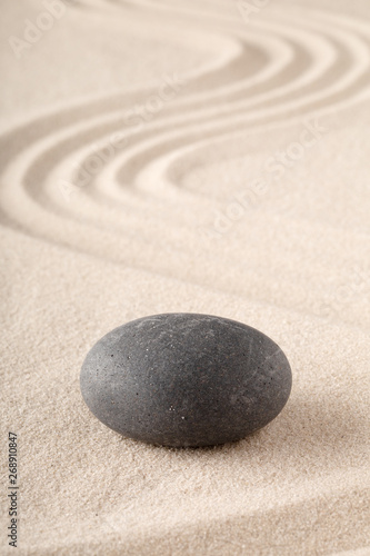 Zen garden with raked sand and round meditation stone for concentration and focus. Concept for balance, harmony and purity in Yoga mindfulness and buddhism.