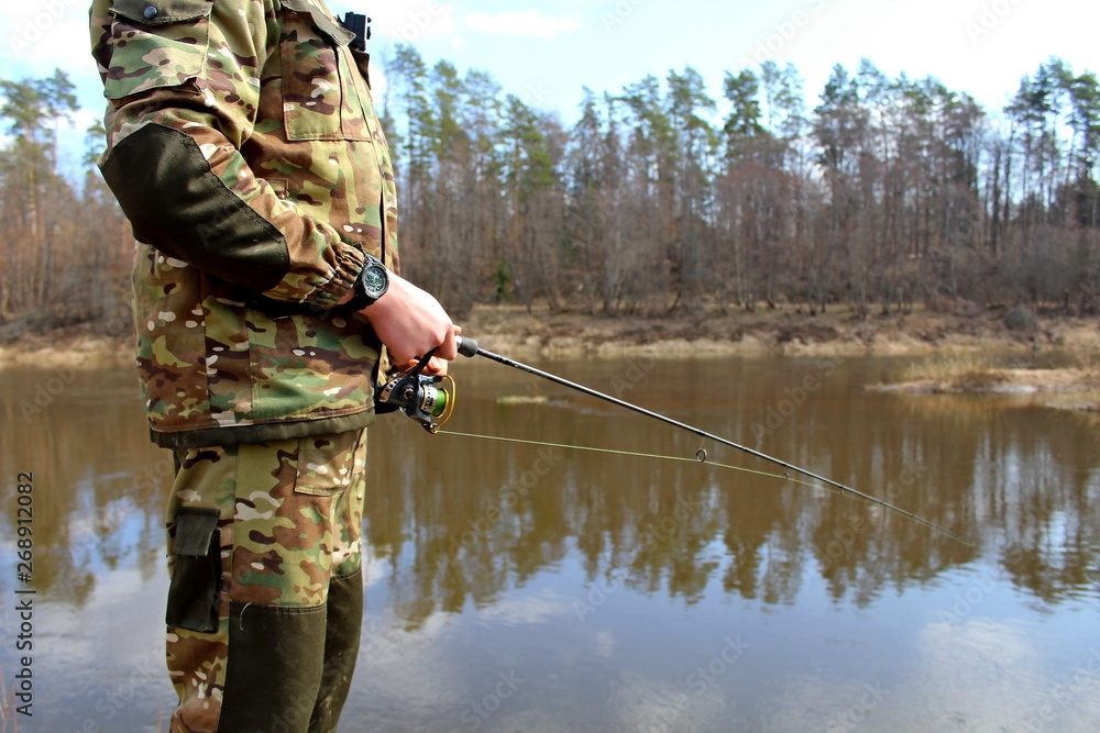 Fisherman in camouflage clothing, fishing on spinning. Fisherman in camouflage clothing, fishing on spinning.