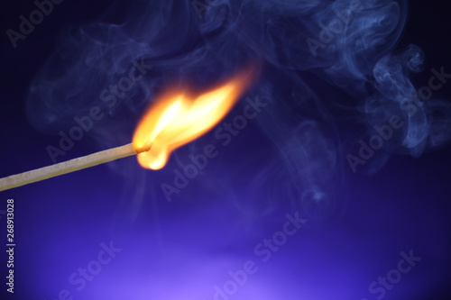 Burning matchstick on color background, closeup. Space for text