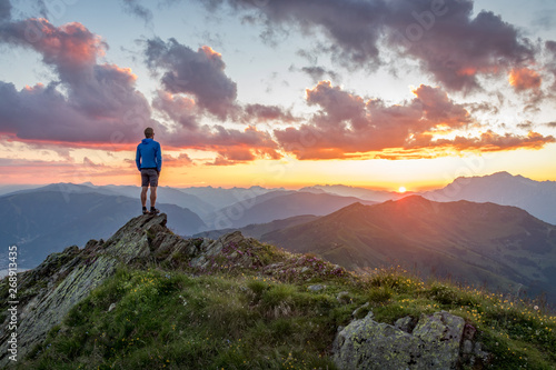 Man watching dramatic sunset in the mountains