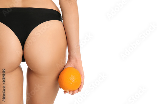 Closeup view of slim woman in underwear with orange on white background. Cellulite problem concept