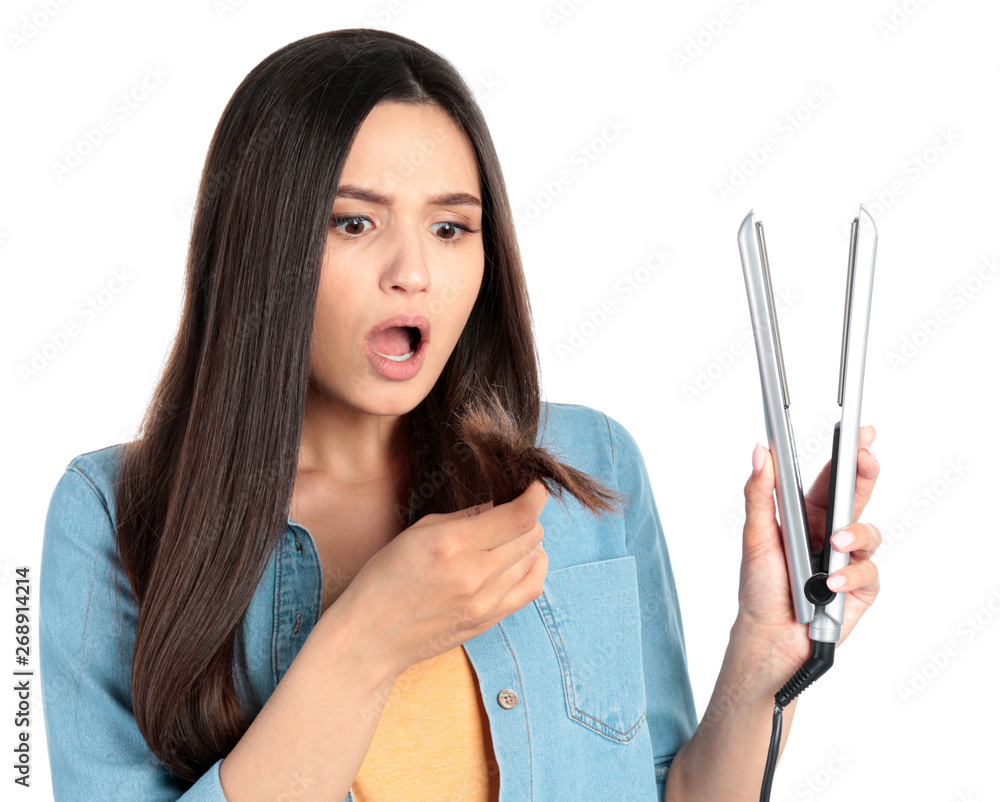 Upset woman with hair iron on white background Upset woman with hair iron on white background
