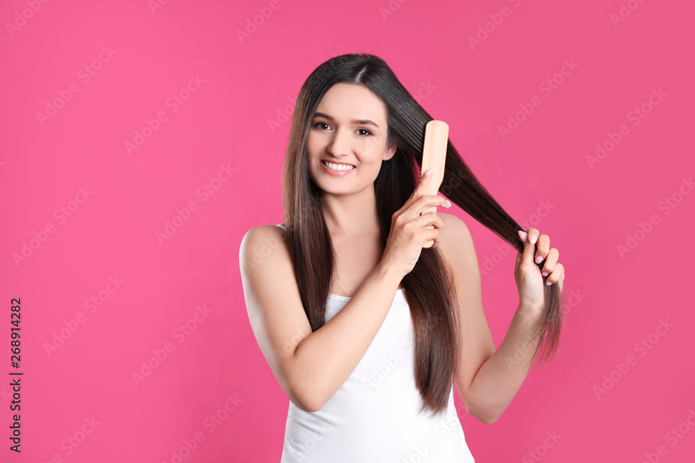Beautiful smiling young woman with hair brush on color background Beautiful smiling young woman with hair brush on color background