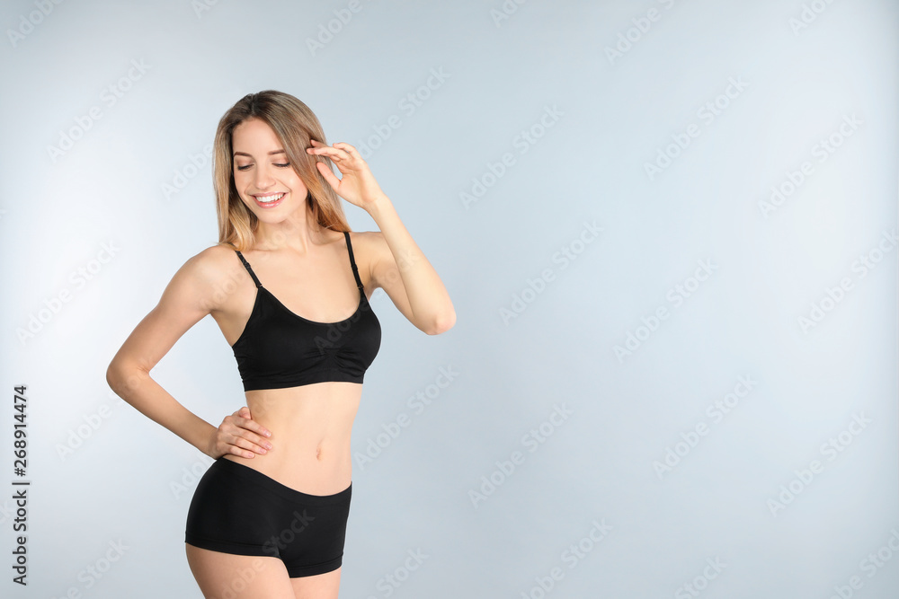 Young slim woman on light background, space for text. Perfect body