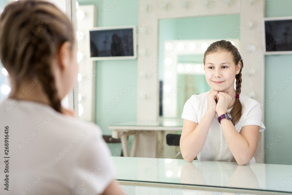 Teenager girl is preparing for casting in front of the mirror in the dressing room Teenager girl is preparing for casting in front of the mirror in the dressing room