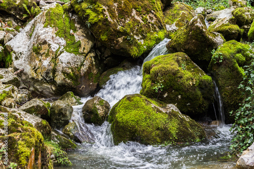 Beautiful view of natural waterfall with crystal clear water among green woods