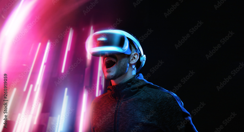Model young man with beard in glasses of virtual reality on dark ...