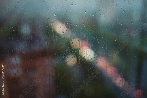 Raindrops, rain behind the window, city on background