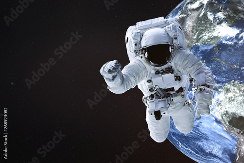 Astronaut near the Earth planet of Solar system. Science fiction. Elements of the image are furnished by NASA