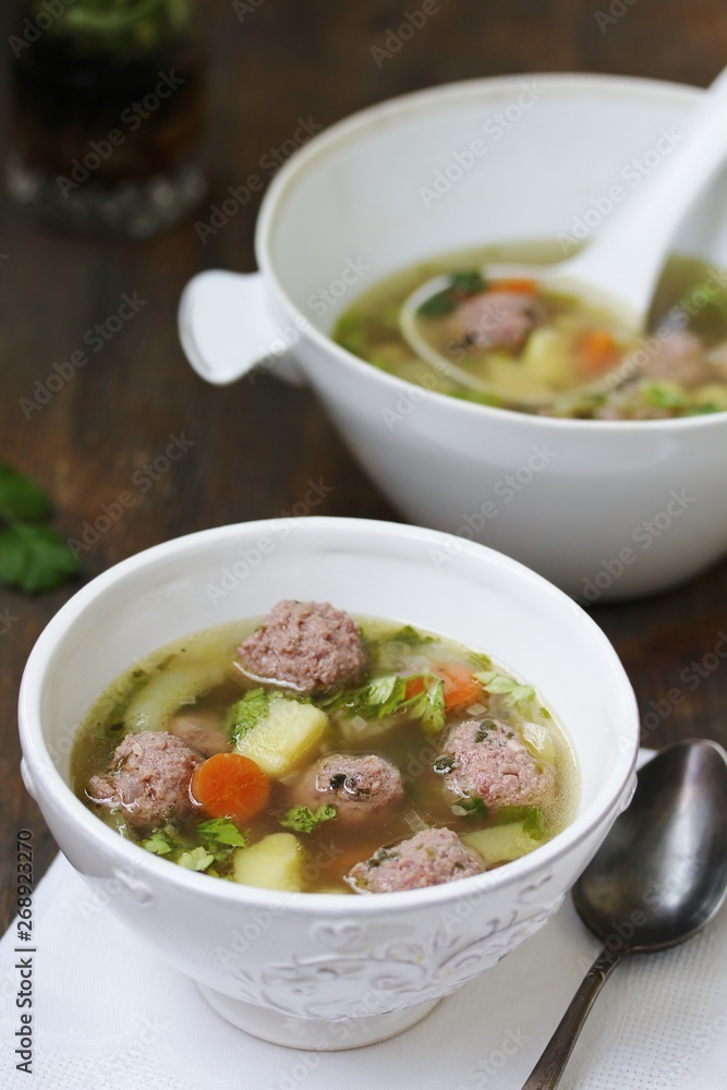 soup with meatballs in a white bowl. light soup with pork meatballs. soup with meatballs in a white bowl. light soup with pork meatballs.