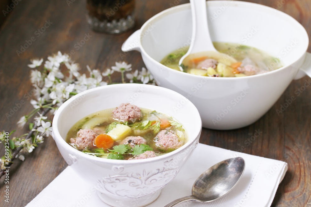 soup with meatballs in a white bowl. light soup with pork meatballs. soup with meatballs in a white bowl. light soup with pork meatballs.
