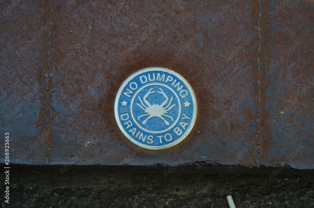 Close up on sign on storm drain, No dumping drains to the Bay