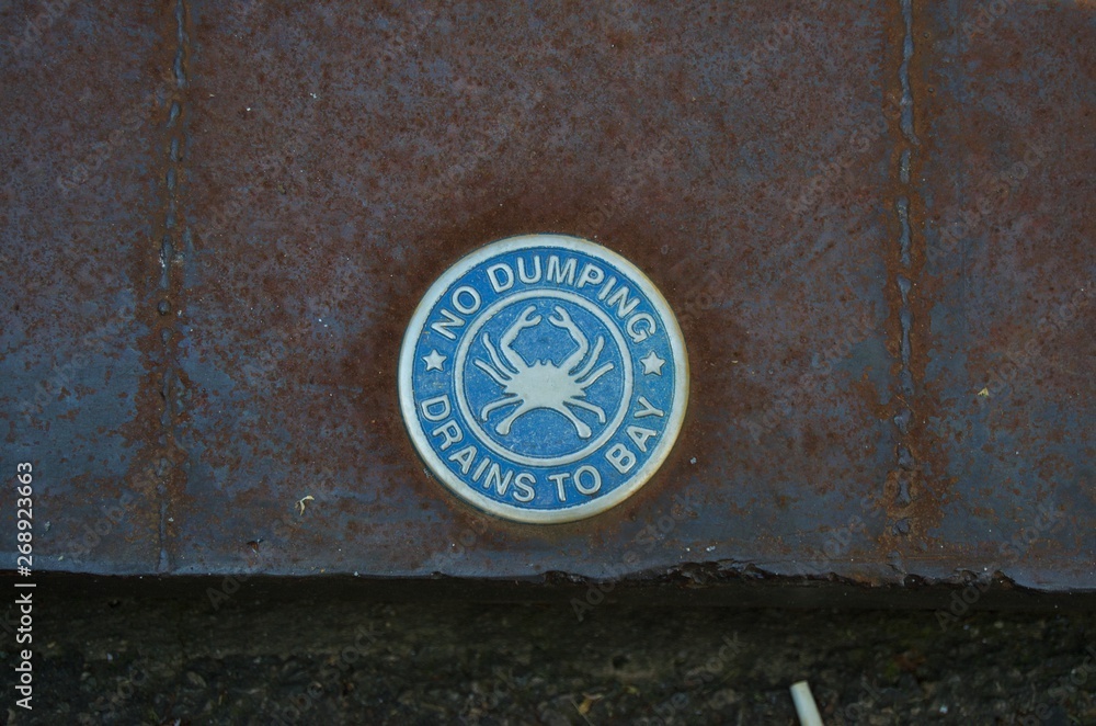 Close up on sign on storm drain, No dumping drains to the Bay Close up on sign on storm drain, No dumping drains to the Bay