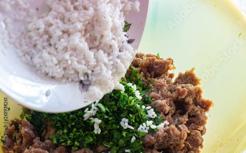 Add rice to the minced meat. Rice on a white plate. Rice on a white plate and minced meat in a container. she puts the rice in minced meat