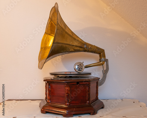 An old gramophone standing on a table, white wall