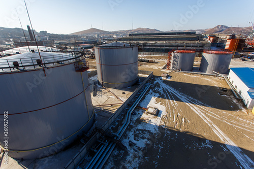 Large silver tanks for the storage of petroleum products in the open. Oil storage.