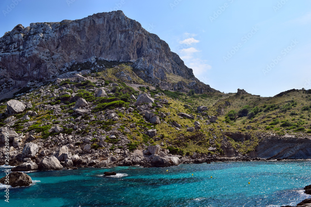 Sea bay with turquoise water, beach and mountains, Cala Figuera on Cap Formentor