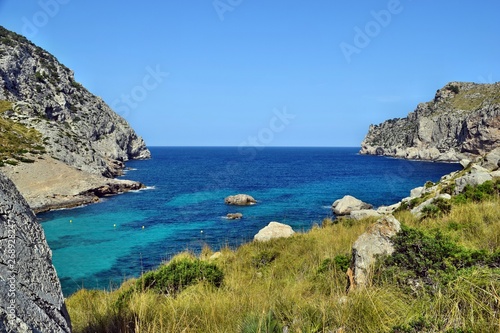 Sea bay with turquoise water, beach and mountains, Cala Figuera on Cap Formentor