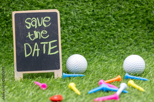 Golf Save the date with golf balls and tee on green grass