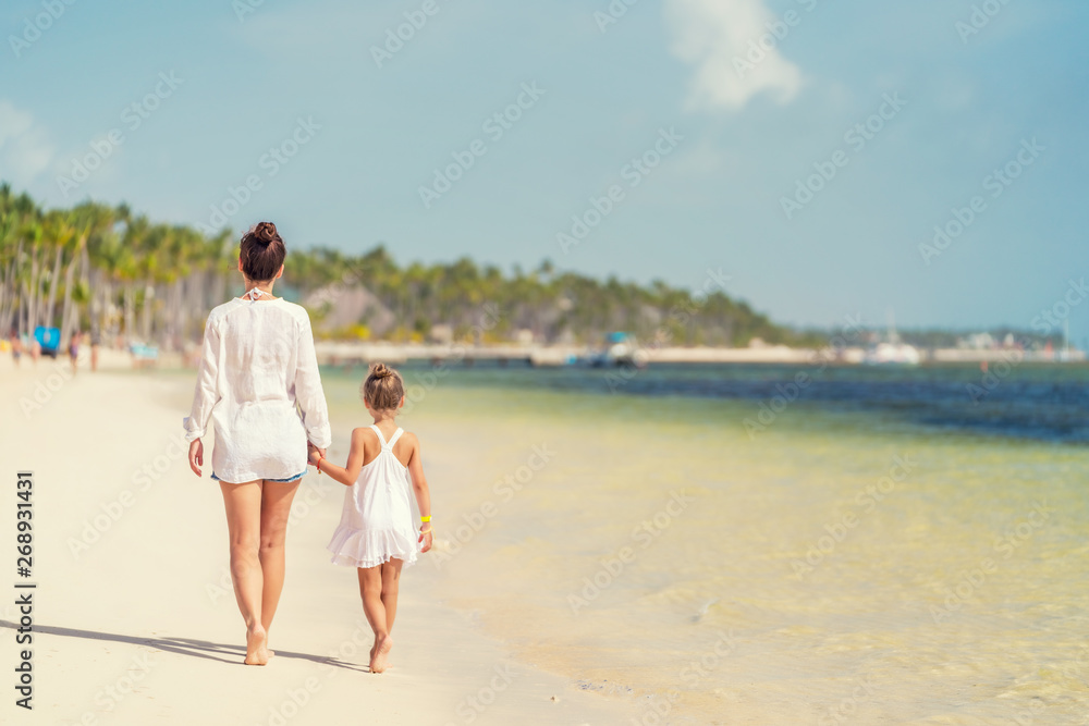 Young mother and little daughter walking on the beach in Dominican Republic Young mother and little daughter walking on the beach in Dominican Republic
