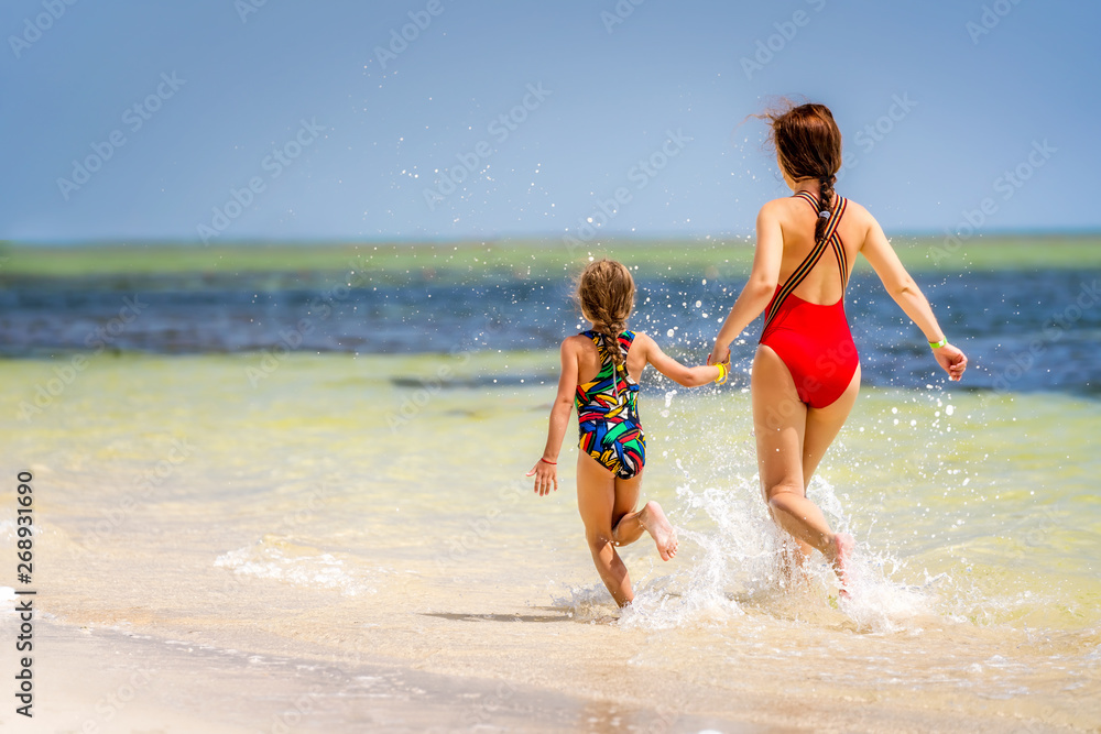 Young mother and little daughter running on the beach in Dominican Republic Young mother and little daughter running on the beach in Dominican Republic
