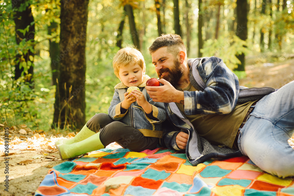 Dad and son in sweaters in the park. Dad and son in the autumn park play