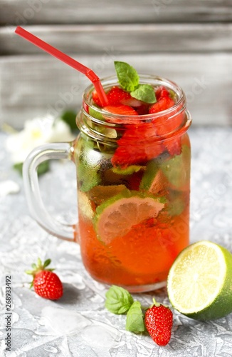 Mojito lemonade with strawberries on a dark background in a trendy mug pot.