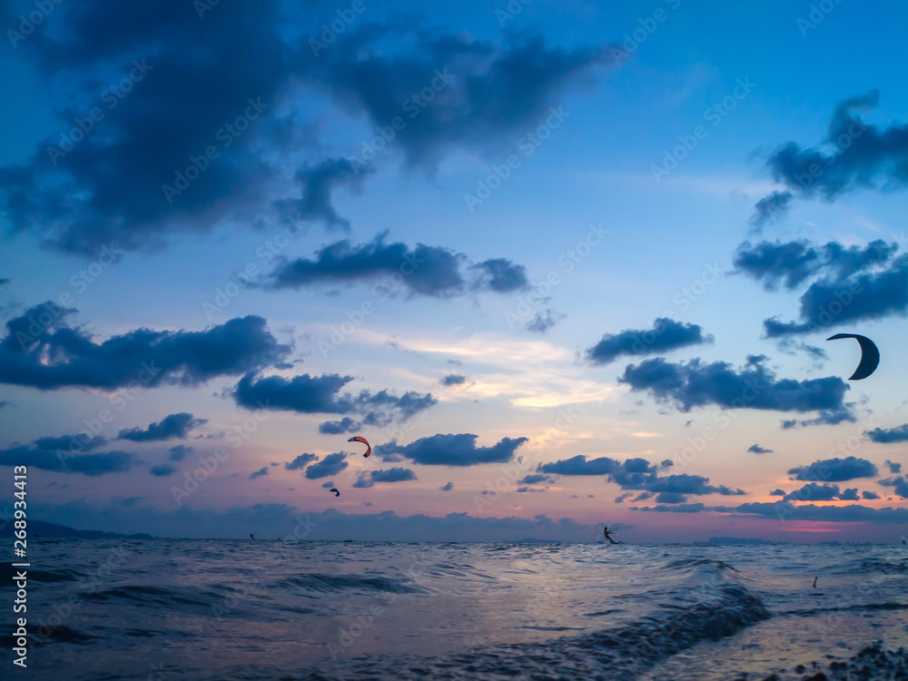 Silhouette people kitesurfing sunset clouds. Koh Phangan. Thailand