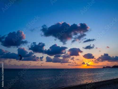 Silhouette people kitesurfing sunset clouds. Koh Phangan. Thailand