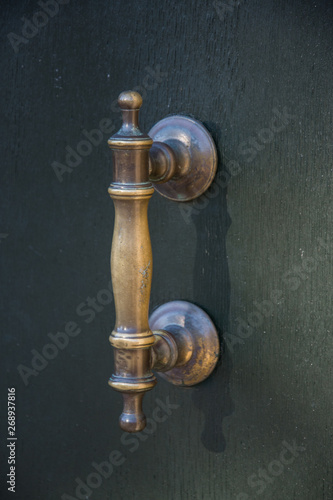 Ancient door handle on a wooden door in Venice, Italy