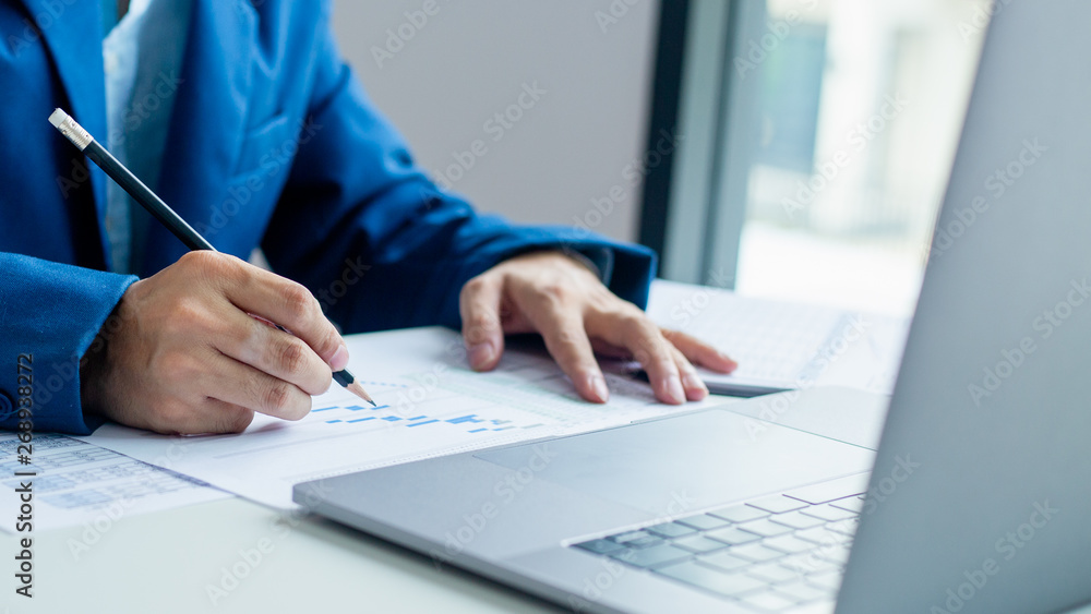 Businessman working and analysis on laptop with financial document data graph of business strategy and market growth at workplace. Businessman working and analysis on laptop with financial document data graph of business strategy and market growth at workplace.