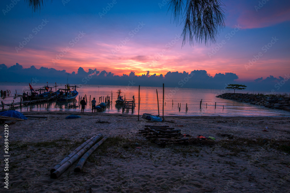 The blurred background of the morning twilight by the sea, changing the color of the beautiful sky, there is a fishing boat docked waiting to go out to find fish again. The blurred background of the morning twilight by the sea, changing the color of the beautiful sky, there is a fishing boat docked waiting to go out to find fish again.