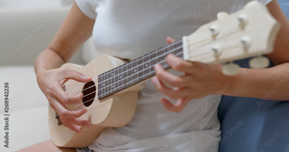Woman play with ukulele at home Woman play with ukulele at home